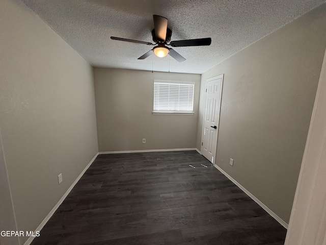 unfurnished room featuring dark wood-style floors, a ceiling fan, baseboards, and a textured ceiling