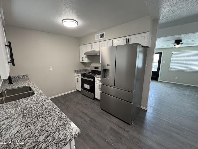 kitchen featuring under cabinet range hood, a sink, visible vents, appliances with stainless steel finishes, and dark wood finished floors