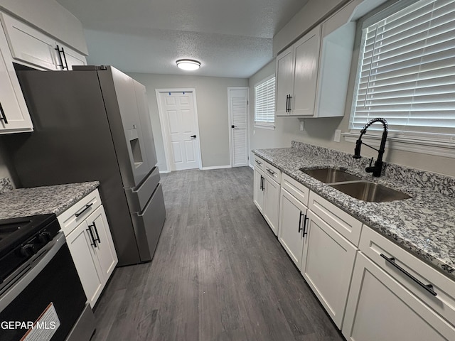 kitchen with dark wood finished floors, white cabinetry, a sink, and a textured ceiling