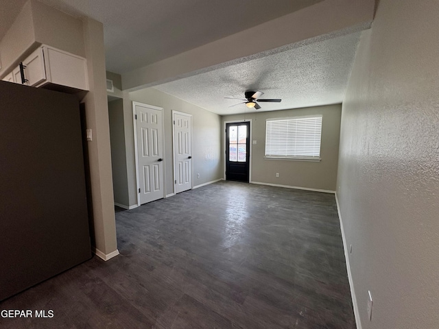 entrance foyer with baseboards, a ceiling fan, dark wood-type flooring, and a textured ceiling