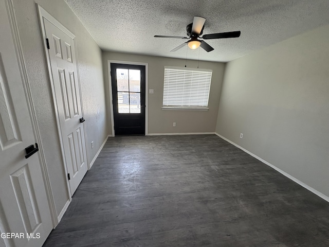 entryway featuring dark wood-type flooring, ceiling fan, a textured ceiling, and baseboards