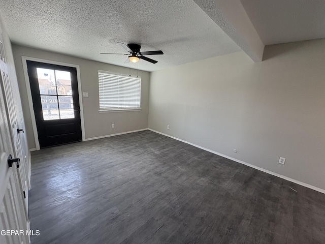 foyer featuring dark wood-style floors, baseboards, and a textured ceiling