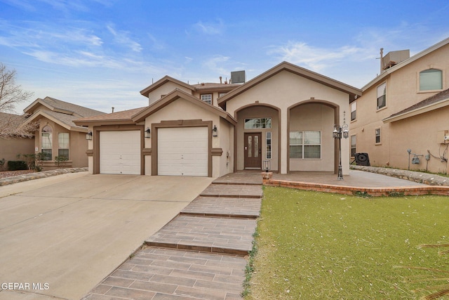 mediterranean / spanish-style house with a garage, driveway, and stucco siding