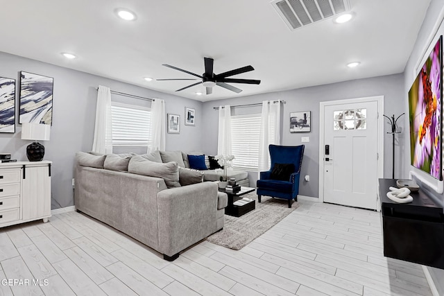 living area featuring light wood-style floors, recessed lighting, visible vents, and a healthy amount of sunlight