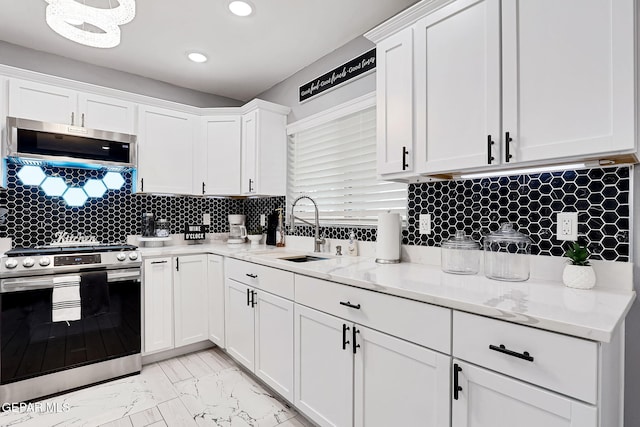 kitchen featuring marble finish floor, appliances with stainless steel finishes, white cabinets, and a sink