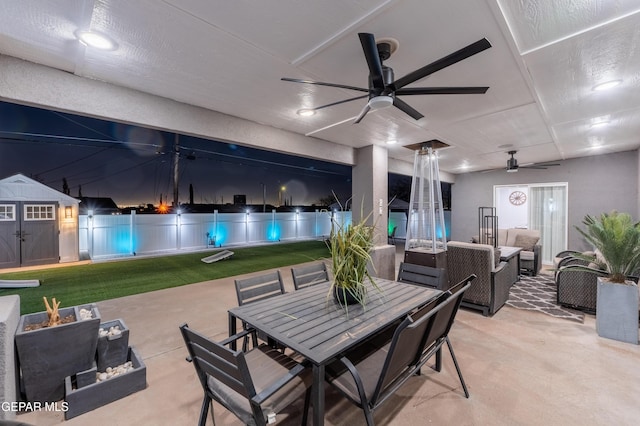 view of patio / terrace with a storage shed, an outdoor hangout area, outdoor dining space, ceiling fan, and an outdoor structure