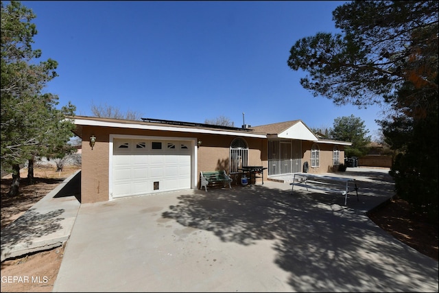 view of front of property with driveway, an attached garage, and stucco siding