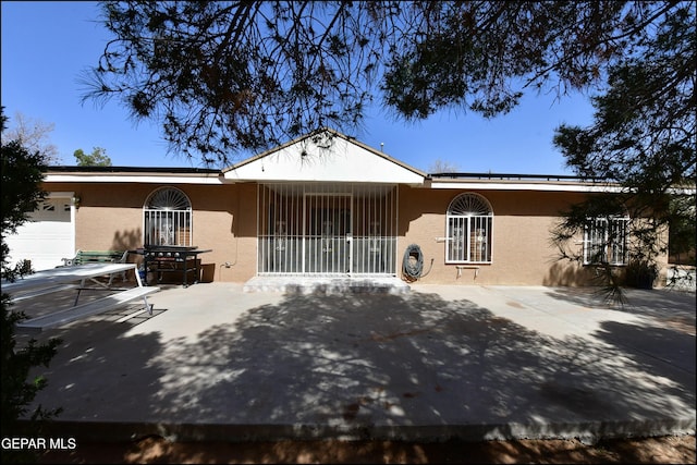 ranch-style home featuring roof mounted solar panels and stucco siding