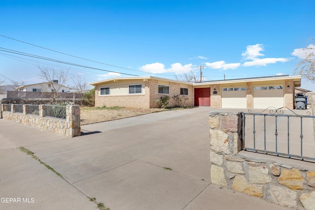 ranch-style house featuring a garage, brick siding, fence, concrete driveway, and a gate