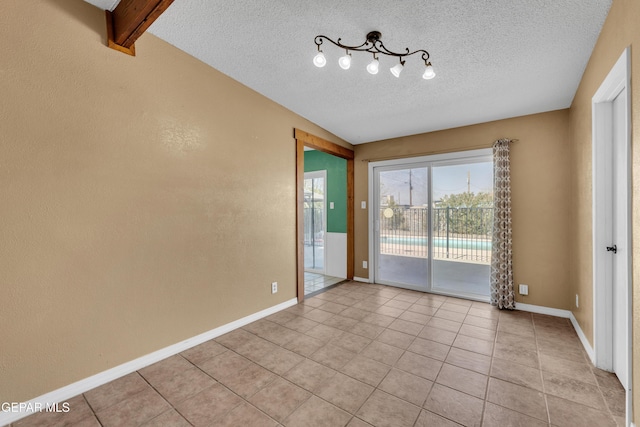 unfurnished room featuring light tile patterned floors, baseboards, and a textured ceiling