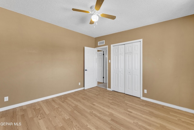 unfurnished bedroom featuring a closet, visible vents, light wood-style flooring, and baseboards