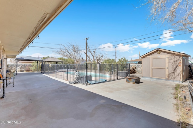 view of patio featuring a storage shed, a fenced in pool, a gazebo, fence, and an outdoor structure