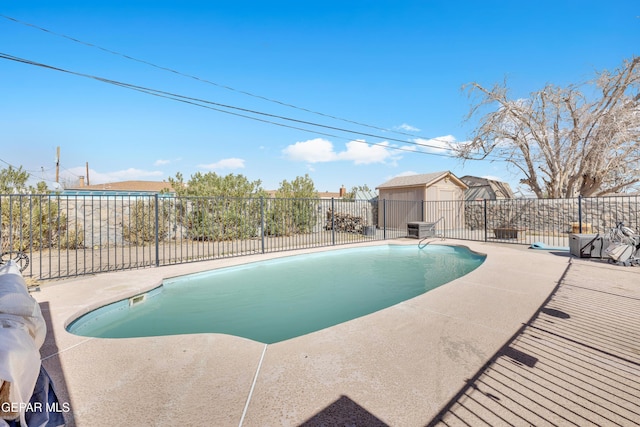 view of swimming pool with fence, an outbuilding, a fenced in pool, and a patio