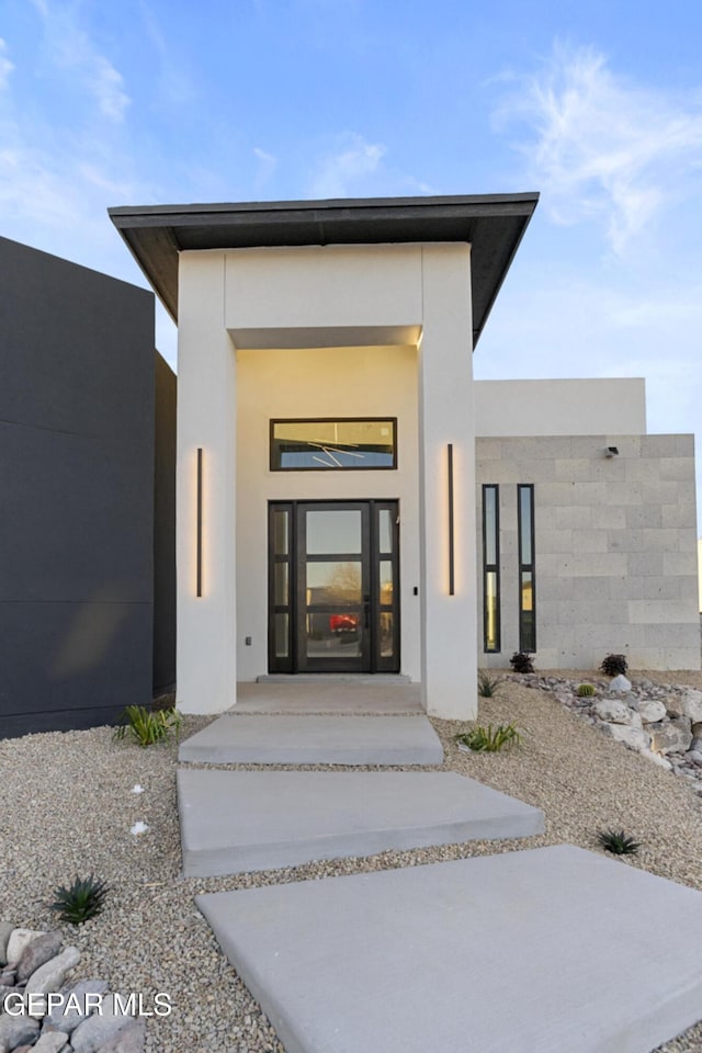 doorway to property featuring stucco siding