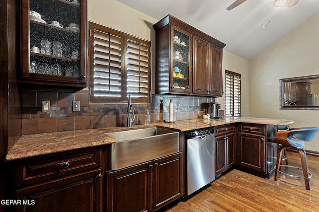 kitchen with dishwasher, dark brown cabinets, and a sink