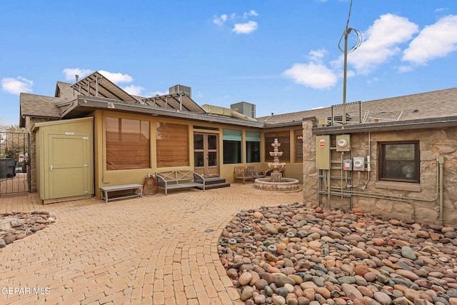 back of house with a shingled roof