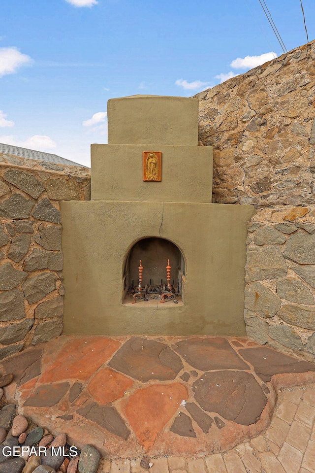 exterior details featuring an outdoor fireplace