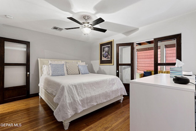 bedroom with dark wood-style floors, visible vents, and a ceiling fan