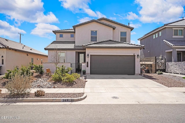 mediterranean / spanish-style house with stucco siding, concrete driveway, a gate, fence, and a tiled roof