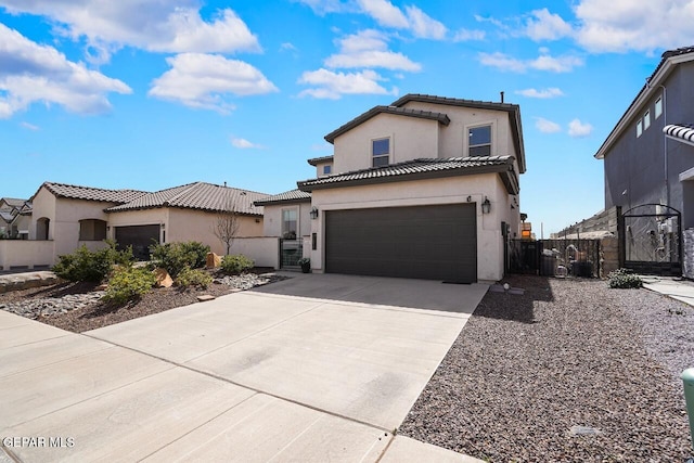 view of front of property featuring concrete driveway, a tiled roof, an attached garage, a gate, and stucco siding