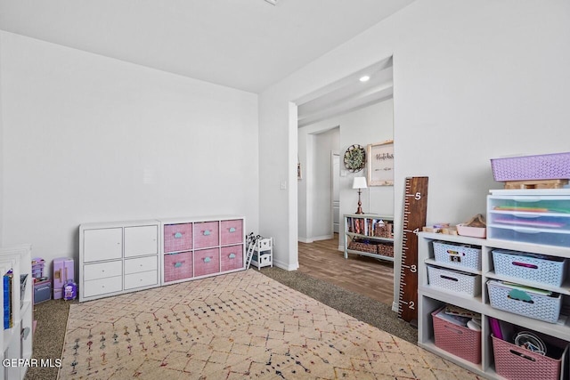 recreation room with carpet and baseboards