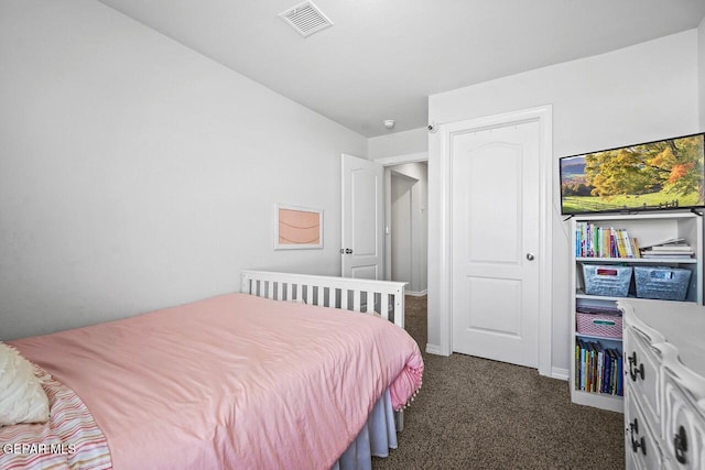 bedroom with dark colored carpet, visible vents, and baseboards