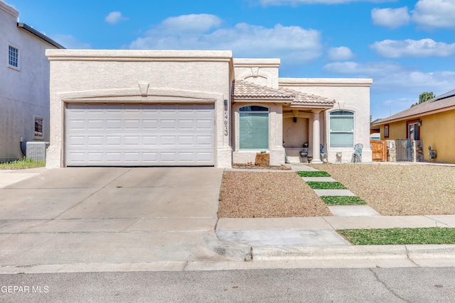 view of front of house with an attached garage, central AC, a tiled roof, driveway, and stucco siding