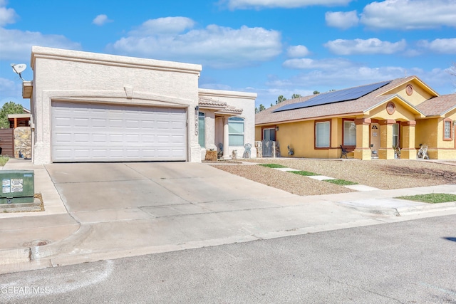 view of front facade with an attached garage, concrete driveway, and stucco siding