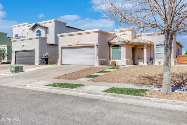 mediterranean / spanish-style house with a tile roof, driveway, an attached garage, and stucco siding