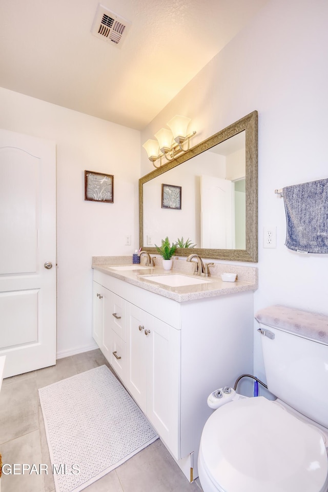 full bath featuring toilet, a sink, and visible vents