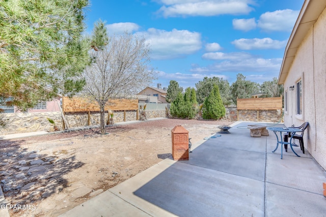 view of patio with a fenced backyard and a fire pit