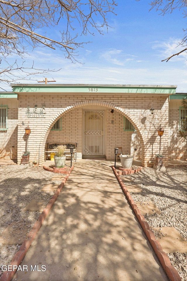 exterior space with driveway and brick siding