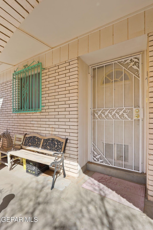 view of exterior entry featuring brick siding