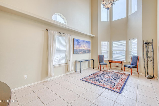 living area with tile patterned flooring, a healthy amount of sunlight, and an inviting chandelier