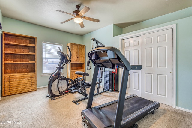 exercise area with baseboards, a ceiling fan, and carpet flooring