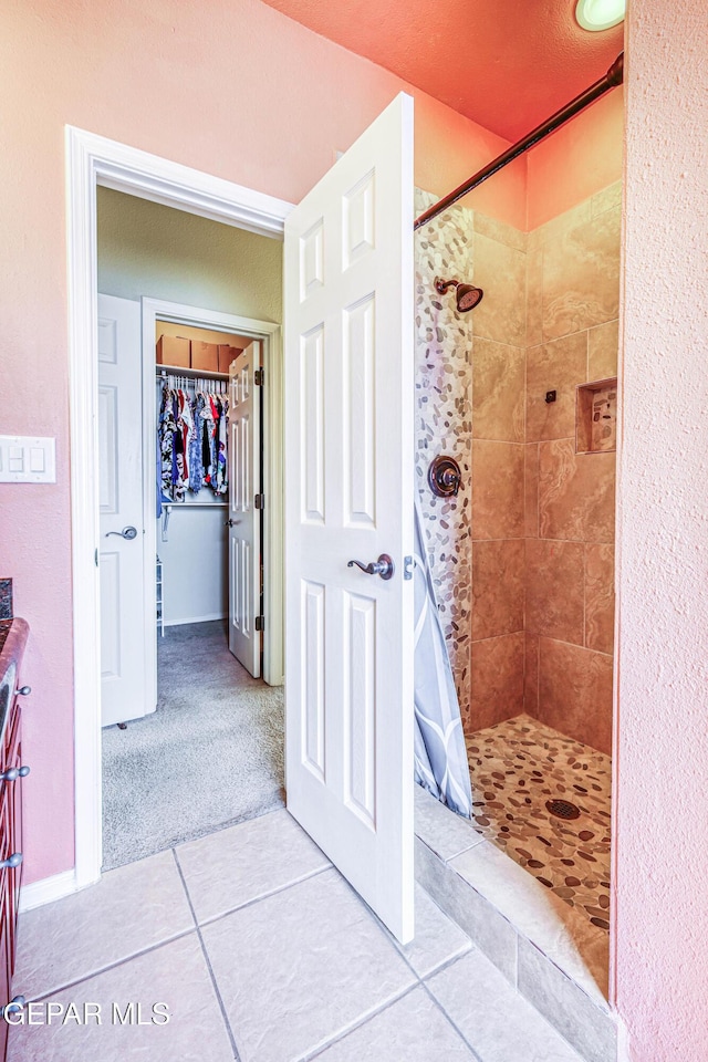 bathroom featuring tile patterned flooring and a shower stall