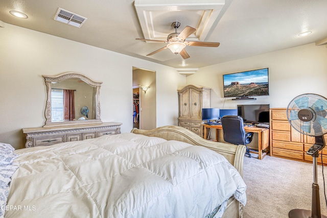 bedroom featuring a walk in closet, carpet flooring, a ceiling fan, and visible vents