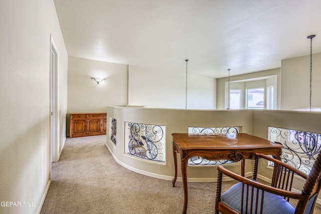 interior space featuring light carpet and baseboards