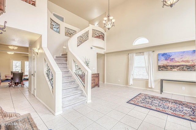 entrance foyer with stairway, plenty of natural light, a chandelier, and tile patterned flooring