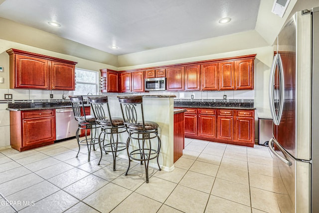 kitchen with stainless steel appliances, a kitchen island, and dark brown cabinets