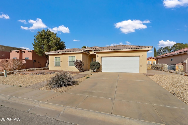 view of front of property with driveway, fence, an attached garage, and stucco siding