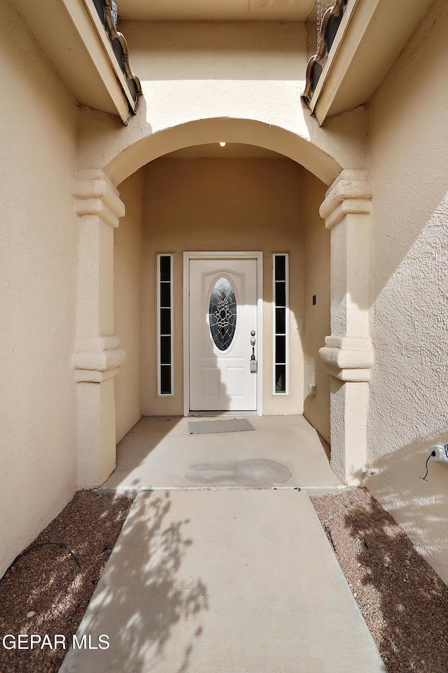 doorway to property featuring stucco siding