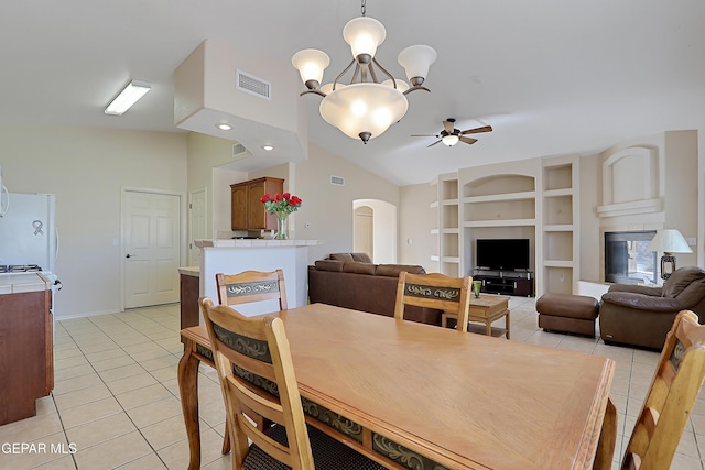 dining space with built in features, arched walkways, light tile patterned floors, lofted ceiling, and visible vents