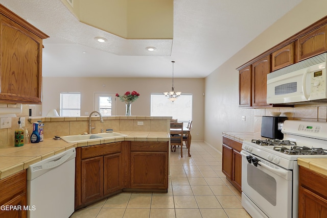 kitchen with tile countertops, light tile patterned floors, white appliances, a sink, and decorative backsplash