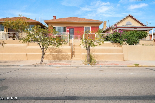 bungalow-style house featuring stairway and fence