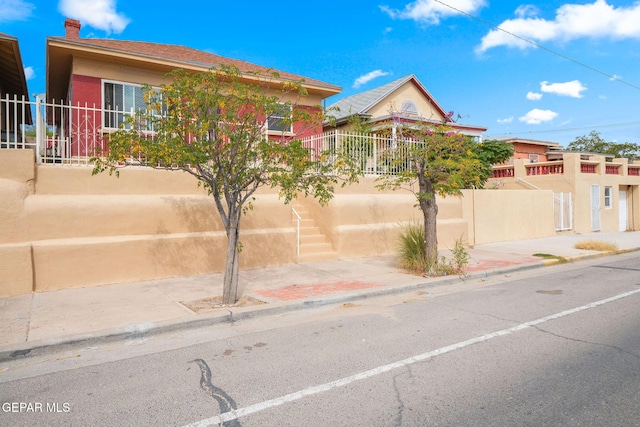 view of front of home featuring fence and a chimney