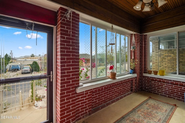 sunroom / solarium featuring wooden ceiling and a ceiling fan