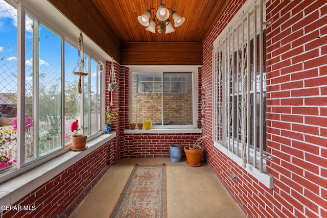 unfurnished sunroom with wooden ceiling and a notable chandelier