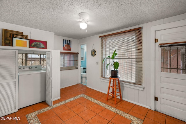 washroom with laundry area, light tile patterned floors, washer / clothes dryer, and a textured ceiling