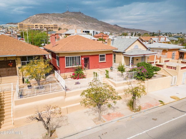 view of front of property with a residential view, fence, a mountain view, and brick siding